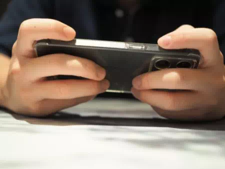 スマホを横向きに持つ若い男性の手元